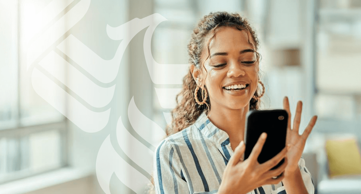 A smiling student answers a call on her phone.