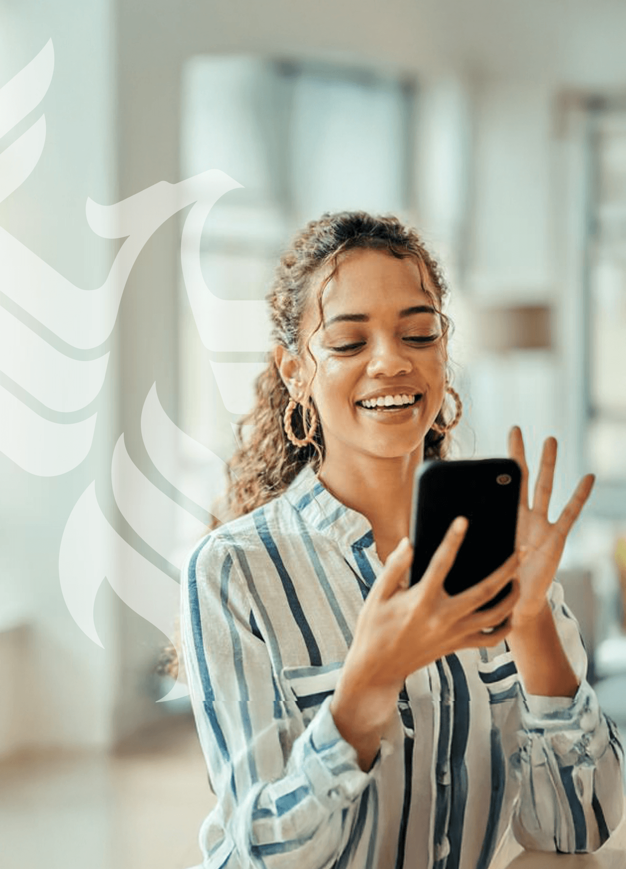 A smiling student answers a call on her phone.