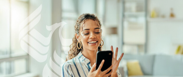 A smiling student answers a call on her phone.