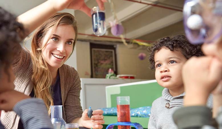 A teacher works with children and prepares to earn an early childhood education degree