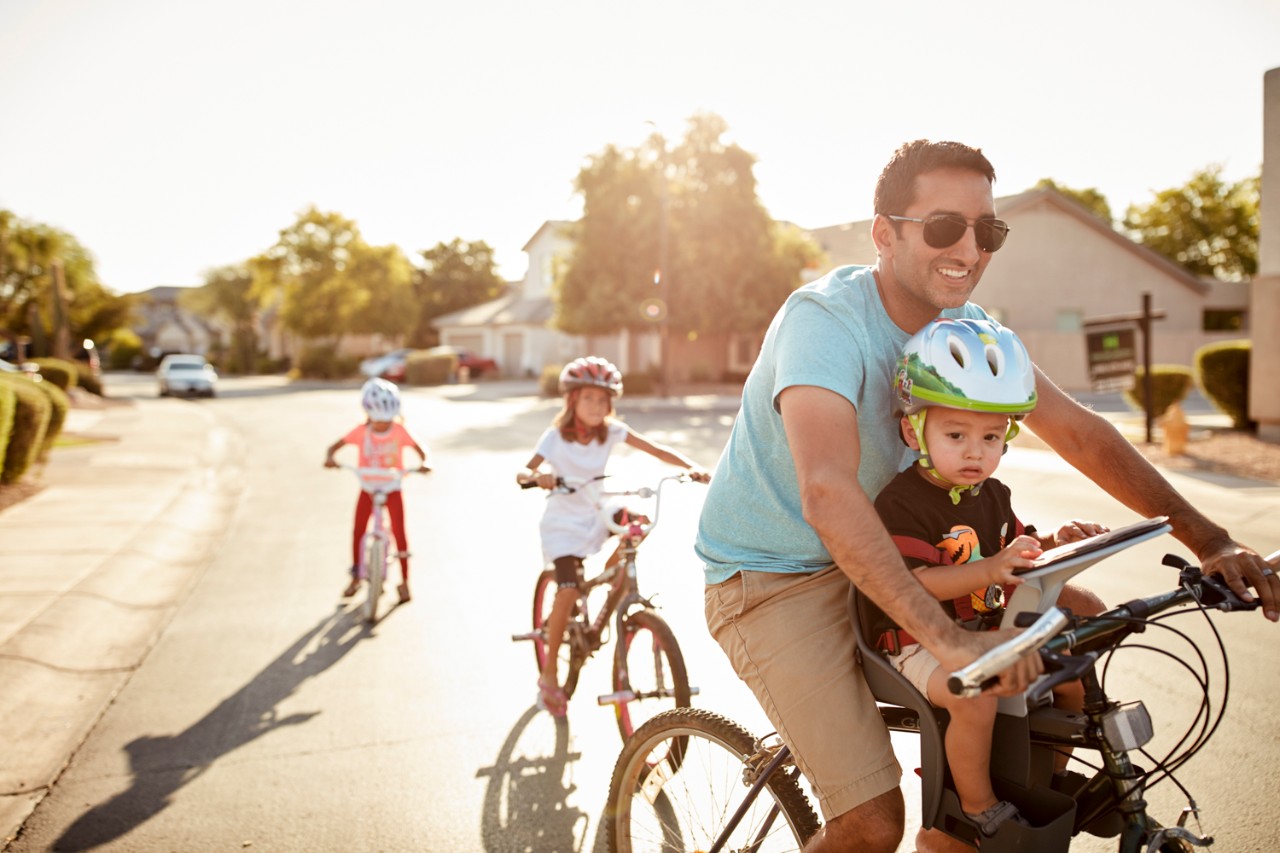 Man riding bikes with children