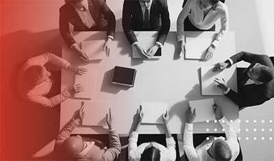 A group of people gathered at a conference table to signify the experts at University of Phoenix