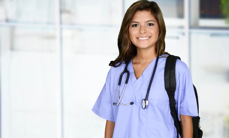 Female nursing student smiling in scrubs