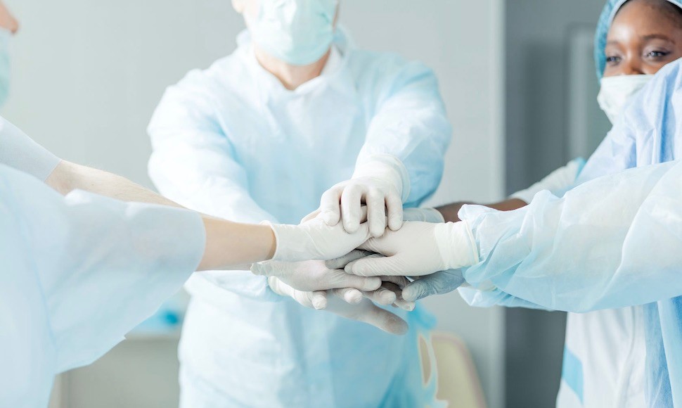 Nurses joining hands and smiling in solidarity 