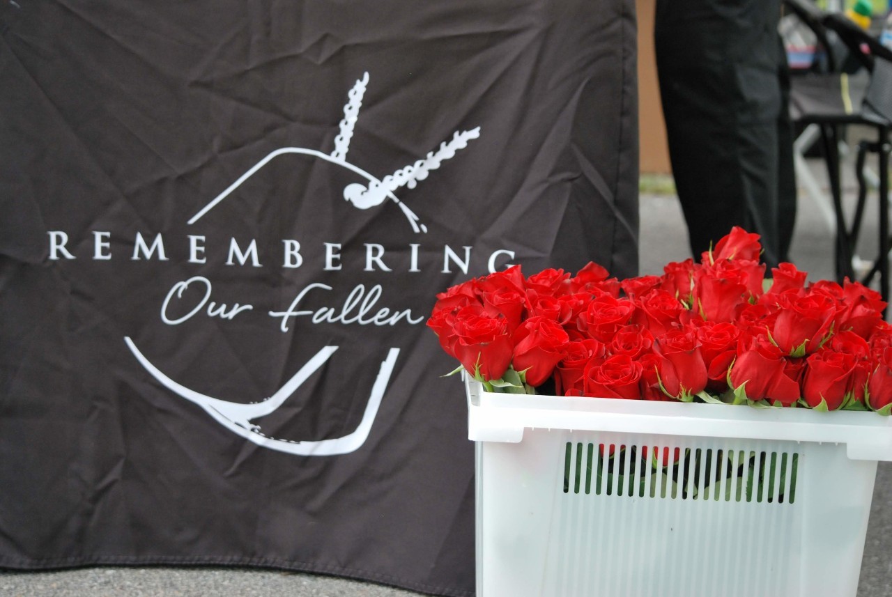 basket with roses beside a Remembering Our Fallen banner