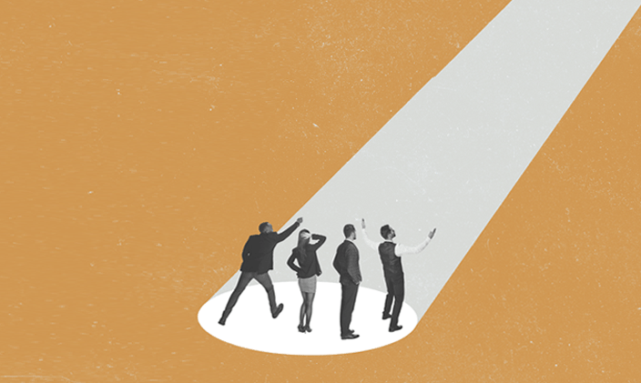 Four people standing in a spotlight looking upward at the light against a gold background.