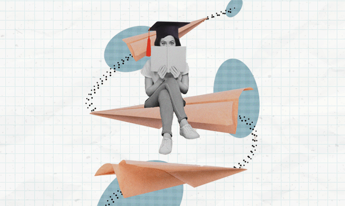 A woman sitting cross-legged reading a book and wearing a graduation cap.