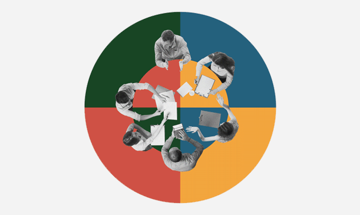 Six people sitting around a table sharing notes with each other.