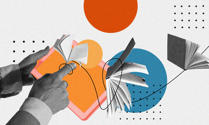 An open book held with two hands and one hand pointing at the right-hand page. 