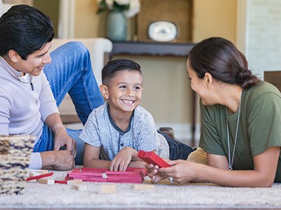 A military member and spouse play with child