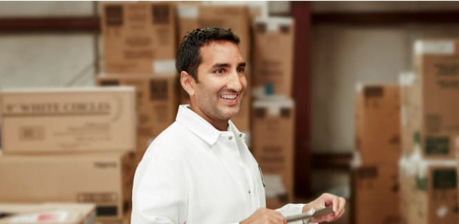 Business student smiling and standing around boxes