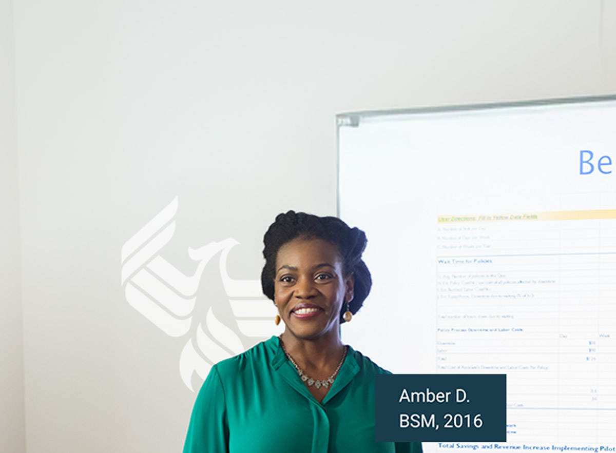 Amber D., BSM, 2016 smiling and standing in front of a projector