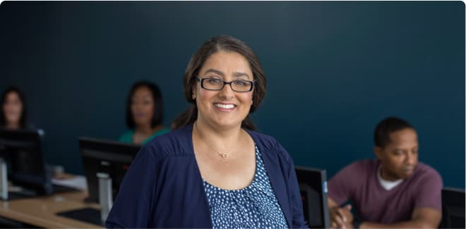 Business students smiling and working in a classroom