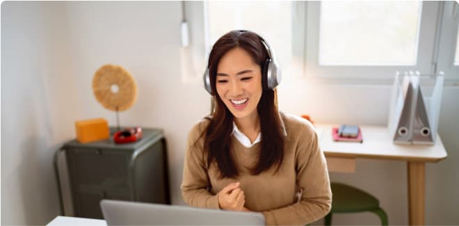 Business student smiling and working on a laptop