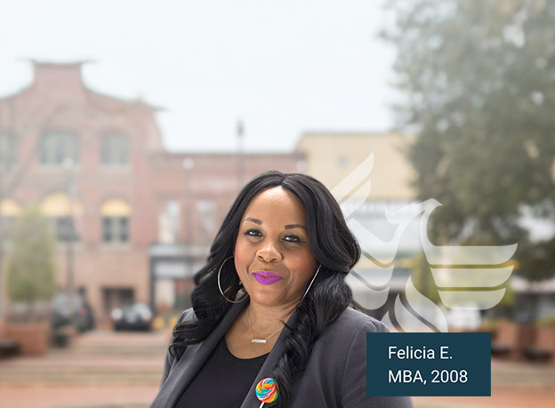 A photo of Felicia E, MBA, 2008, smiling at the camera and standing on campus