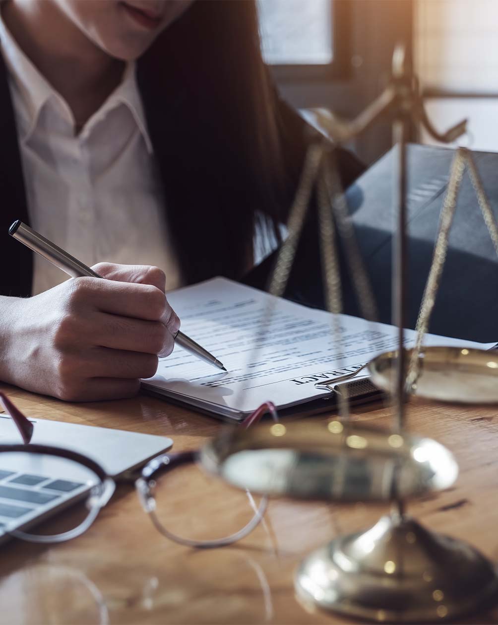 Lawyer filling out paperwork with a desk the scales of justice