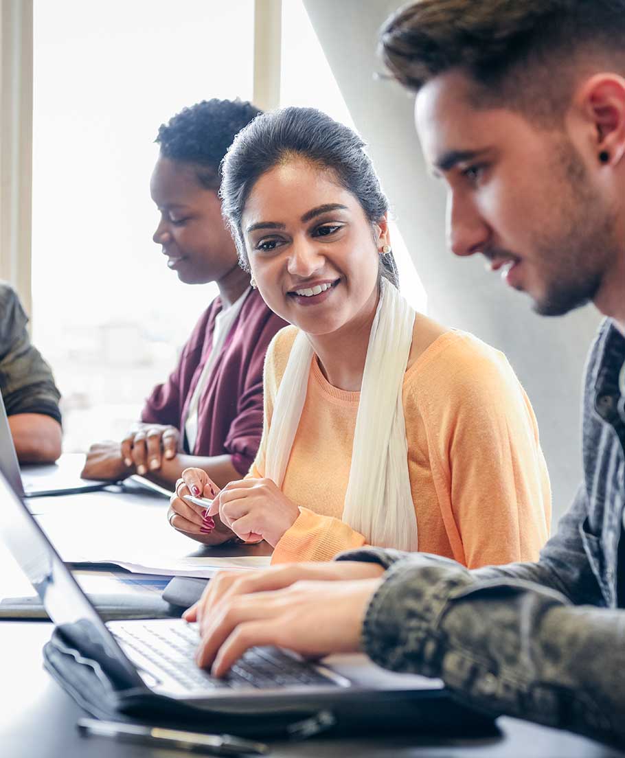 Classmates looking over classwork on a laptop