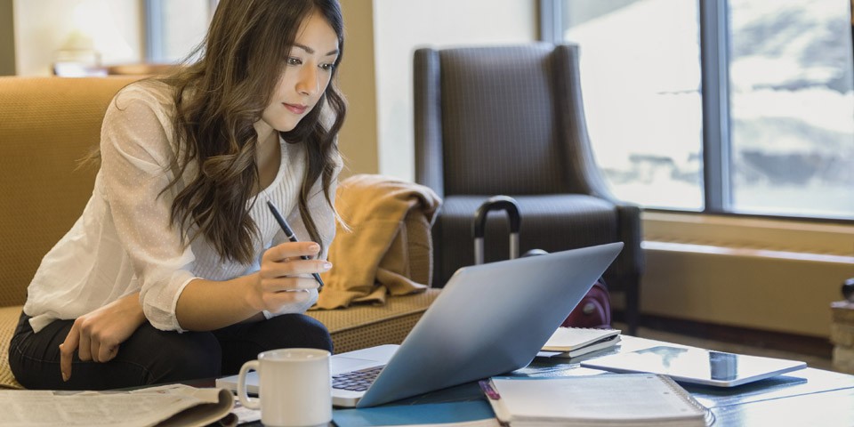 Student writing dissertation on laptop computer