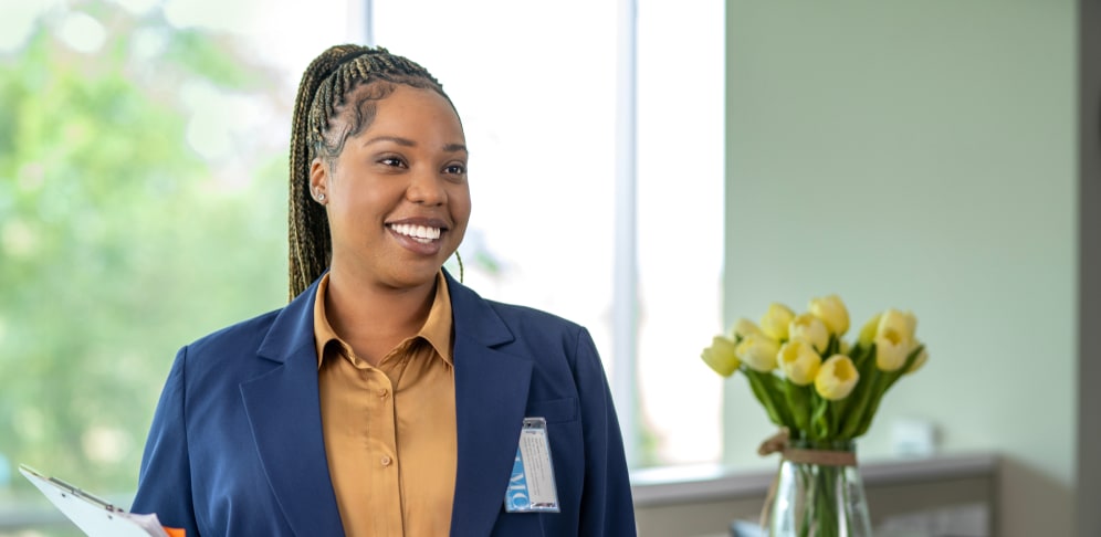Healthcare worker smiling and standing in office attire