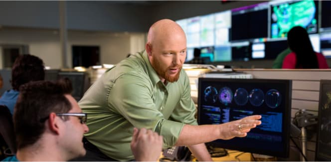 Software developers collaborating in an office with a computer monitor