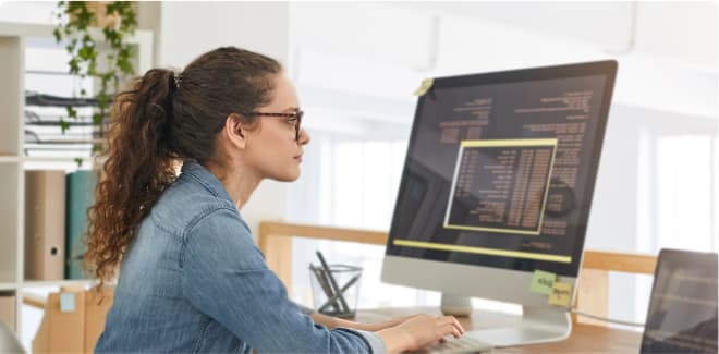 Software developer student working on a computer in an office