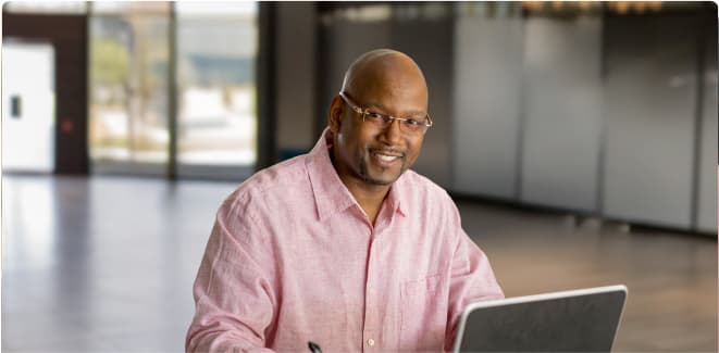 Software developer student smiling and working on a computer