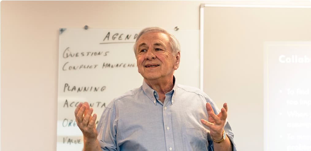 An instructor explains a concept at a whiteboard, bringing practical knowledge to the classroom with real-world expertise.