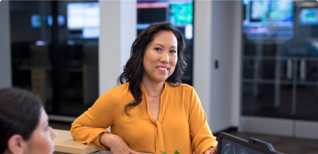  A confident smiling woman in a blazer symbolizes the flexibility of taking online classes while being a professional.