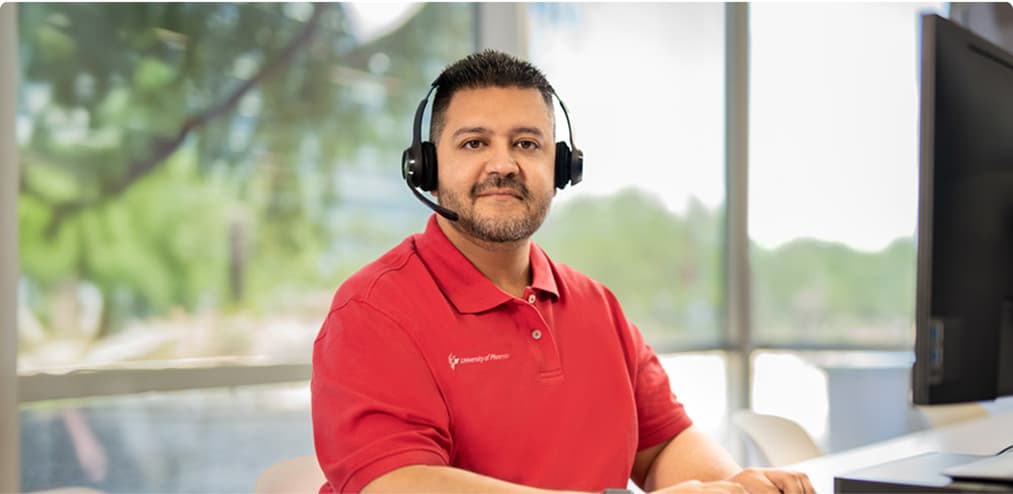 A University of Phoenix representative working at a desk