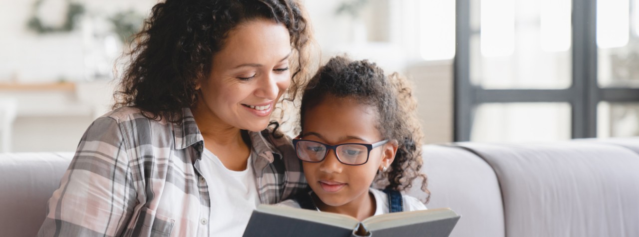Mom and daughter reading a book together