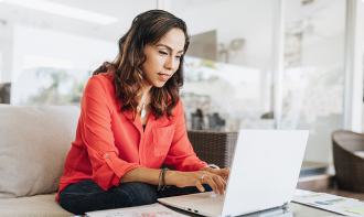 Woman working on a laptop at home in a comfortable setting