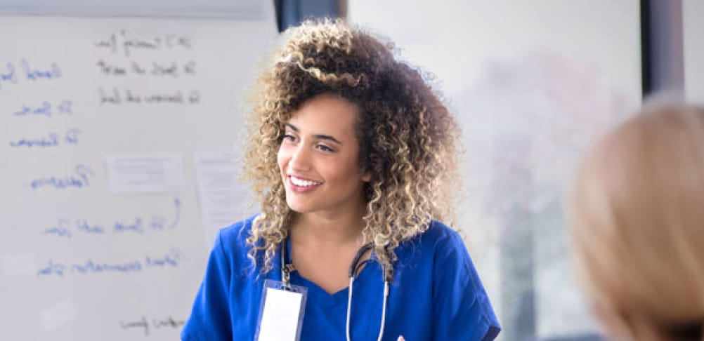 Nursing instructor teachers other nursing students in a classroom.