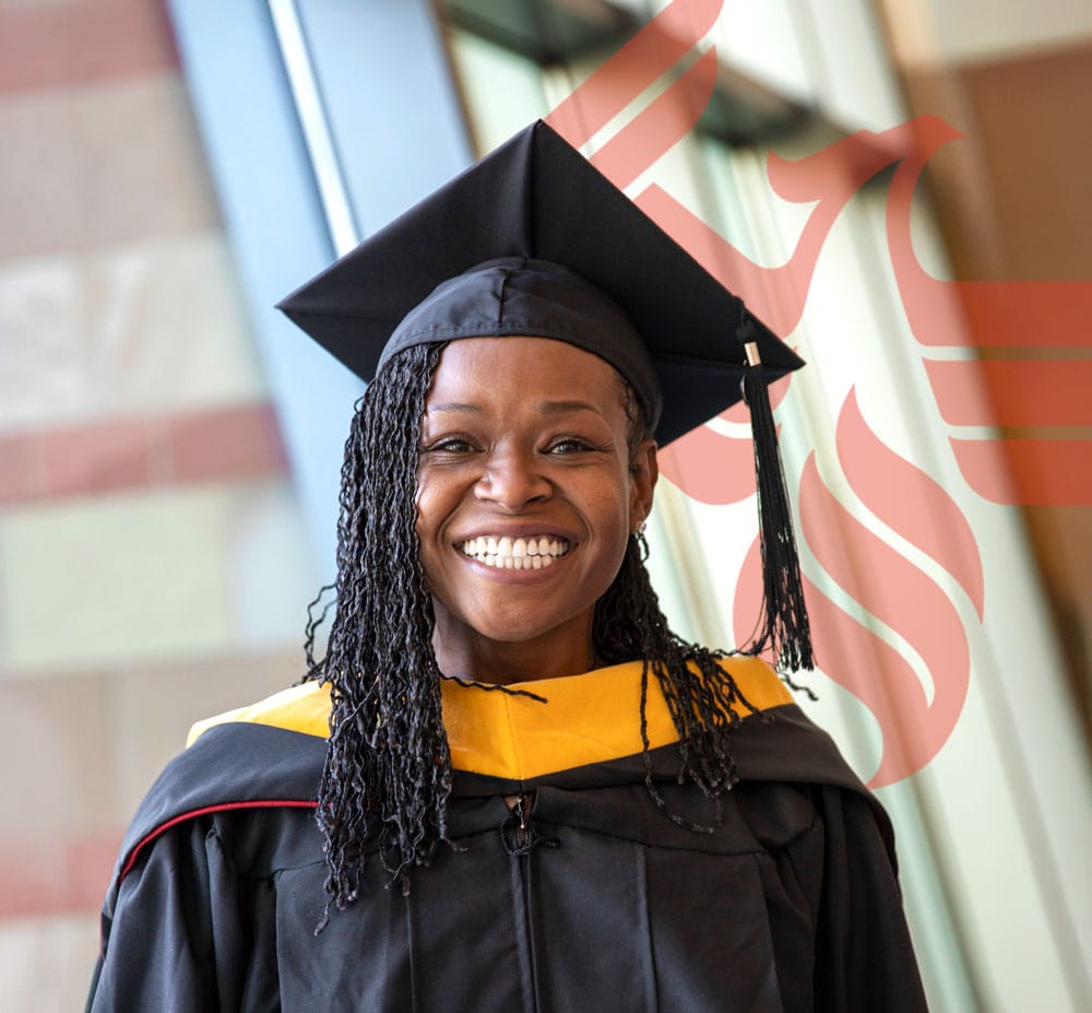 Smiling new graduate waits to receive her diploma.