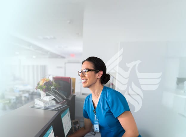 Nursing professional works the front desk of a medical center. 
