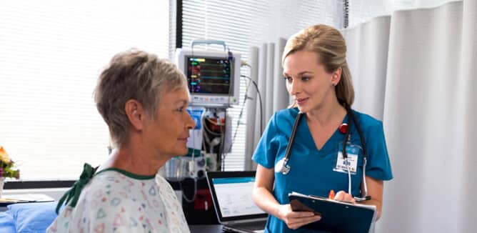 A nurse consults with a patient in a hospital setting.