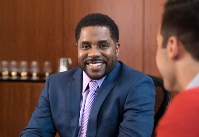  A confident, smiling alumna works with a colleague in an office