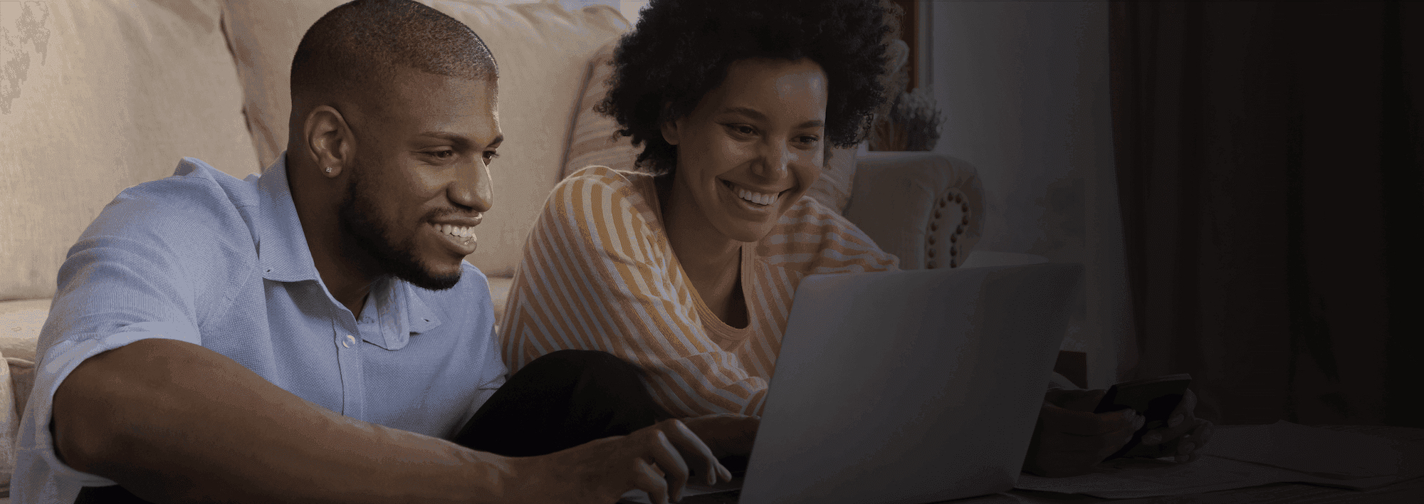 man and woman looking at laptop smiling