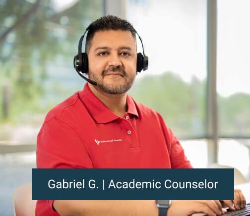 Gabrielle G. Enrollment representative sitting at his computer with headset on and smiling