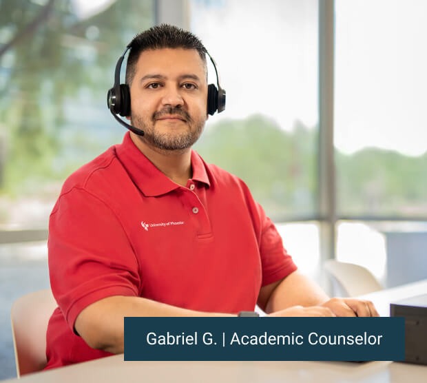 Gabrielle G. Enrollment representative sitting at his computer with headset on and smiling