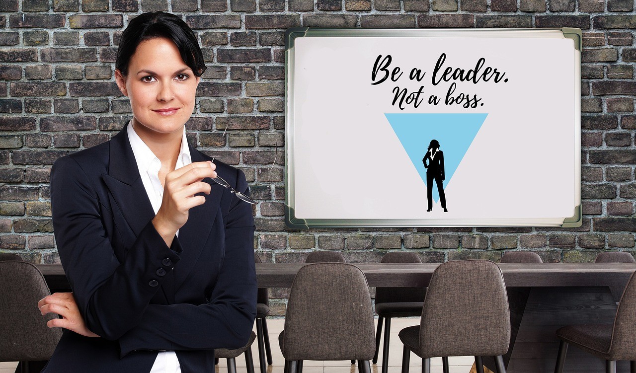 business woman posing and a sign that reads 'be a leader, not a boss"