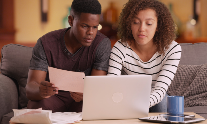 A pair of students work together over a laptop