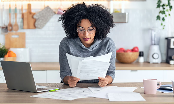 A researcher examines some papers from her kitchen counter