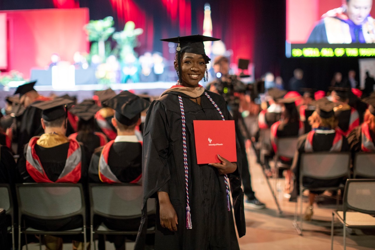 Student at graduation holding a diploma