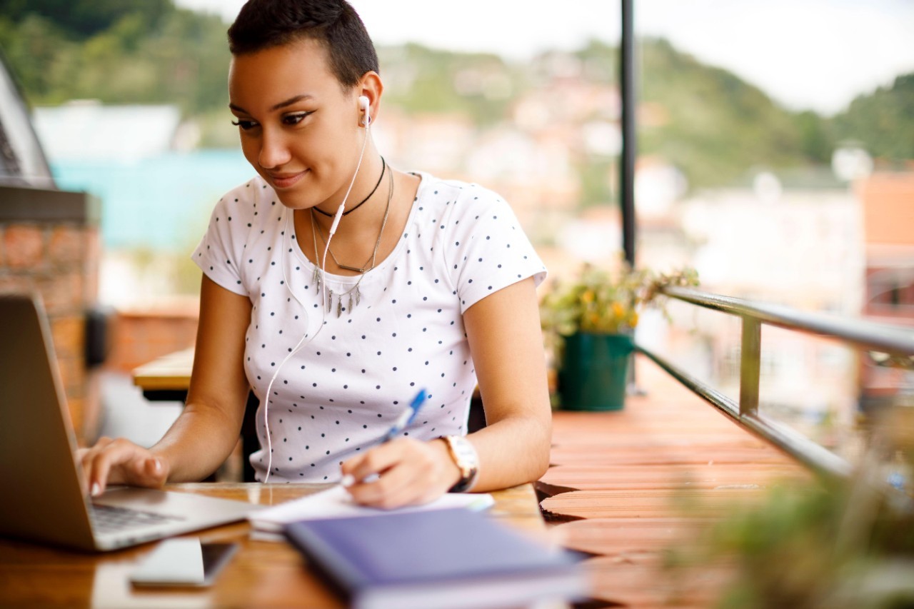 Student sitting outside accesses resources on a laptop