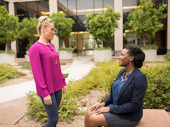 women speaking outdoors