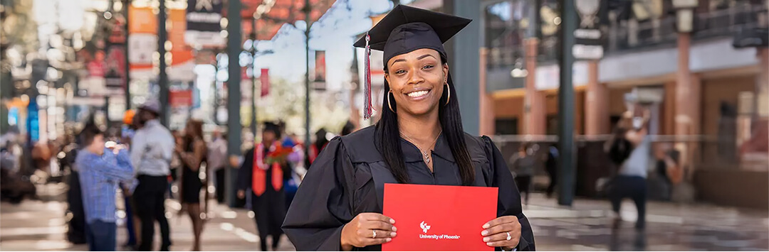 University of Phoenix grad posing with diploma