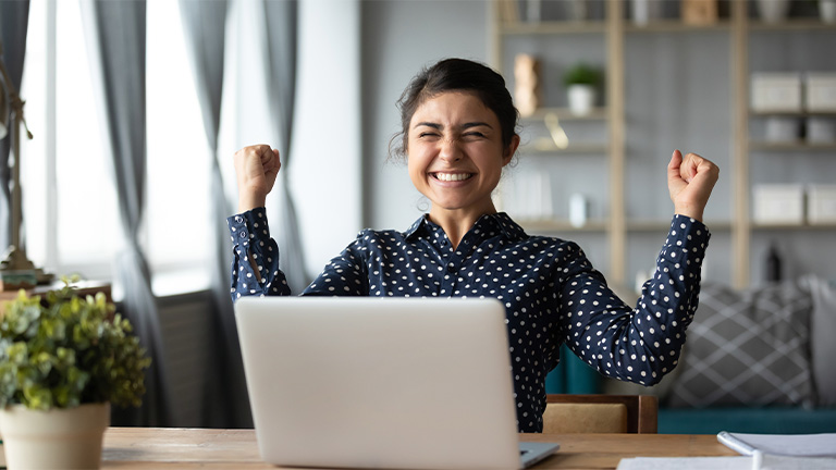 Woman at computer excited about her savings possibilities.