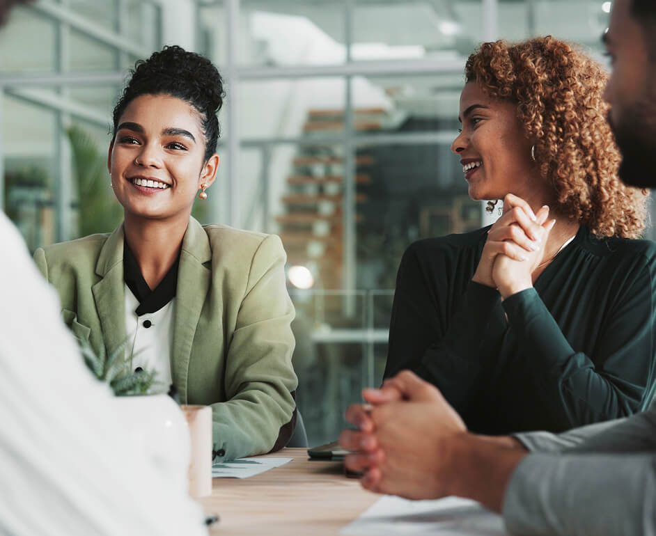 Four workers at a meeting discuss the new roles available at work.